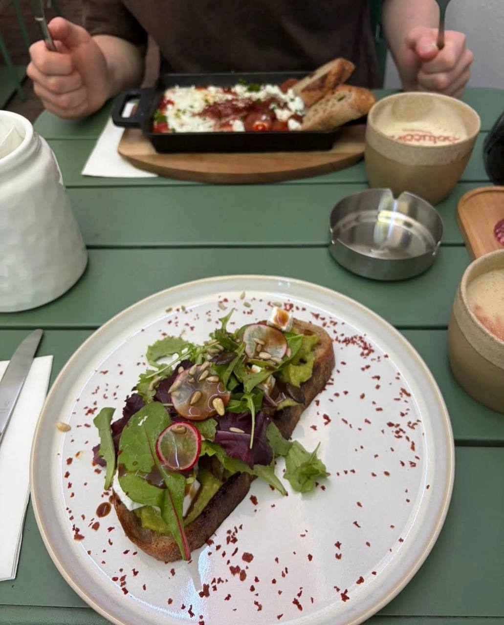 Brunch auf dem grünen Tisch vor dem Café